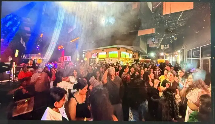 A packed dance floor under stage lights at the Dallas Whistle Podu show.
